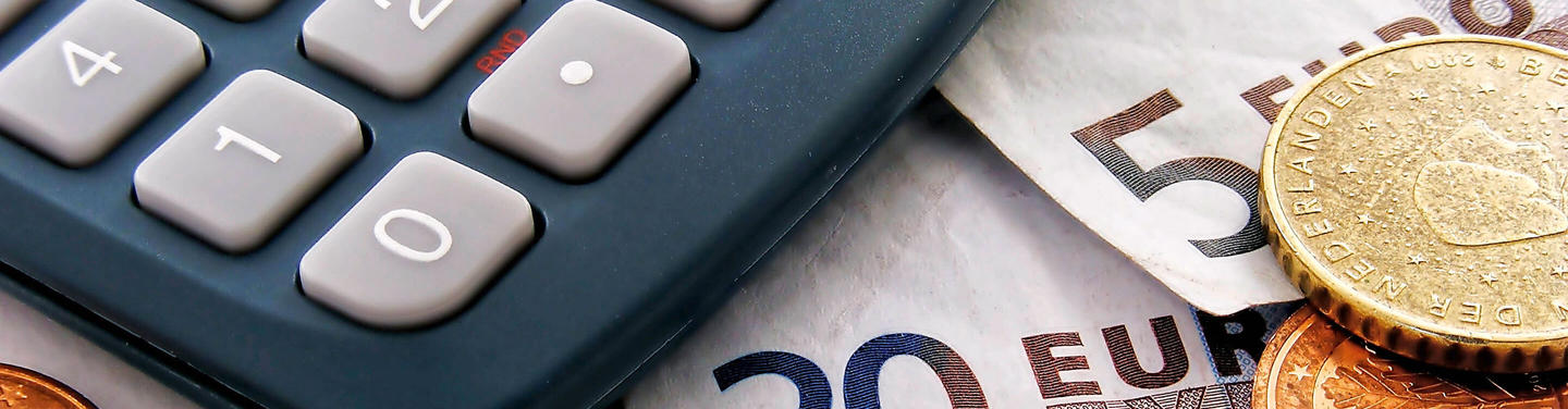 Postbank-Service am Flughafen München Nahaufnahme eines Taschenrechners neben Euro-Banknoten und -Münzen als Symbol für Postbank- und Finanzservices am Flughafen München; die Darstellung wirkt neutral, klar und informativ.