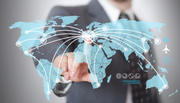 Geschäftsmann berührt eine digitale Weltkarte mit visualisierten globalen Netzwerk- und Flugverbindungen.