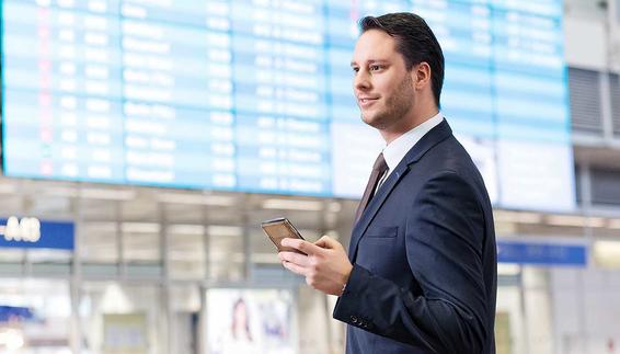Businessreisender vor Abflugtafel