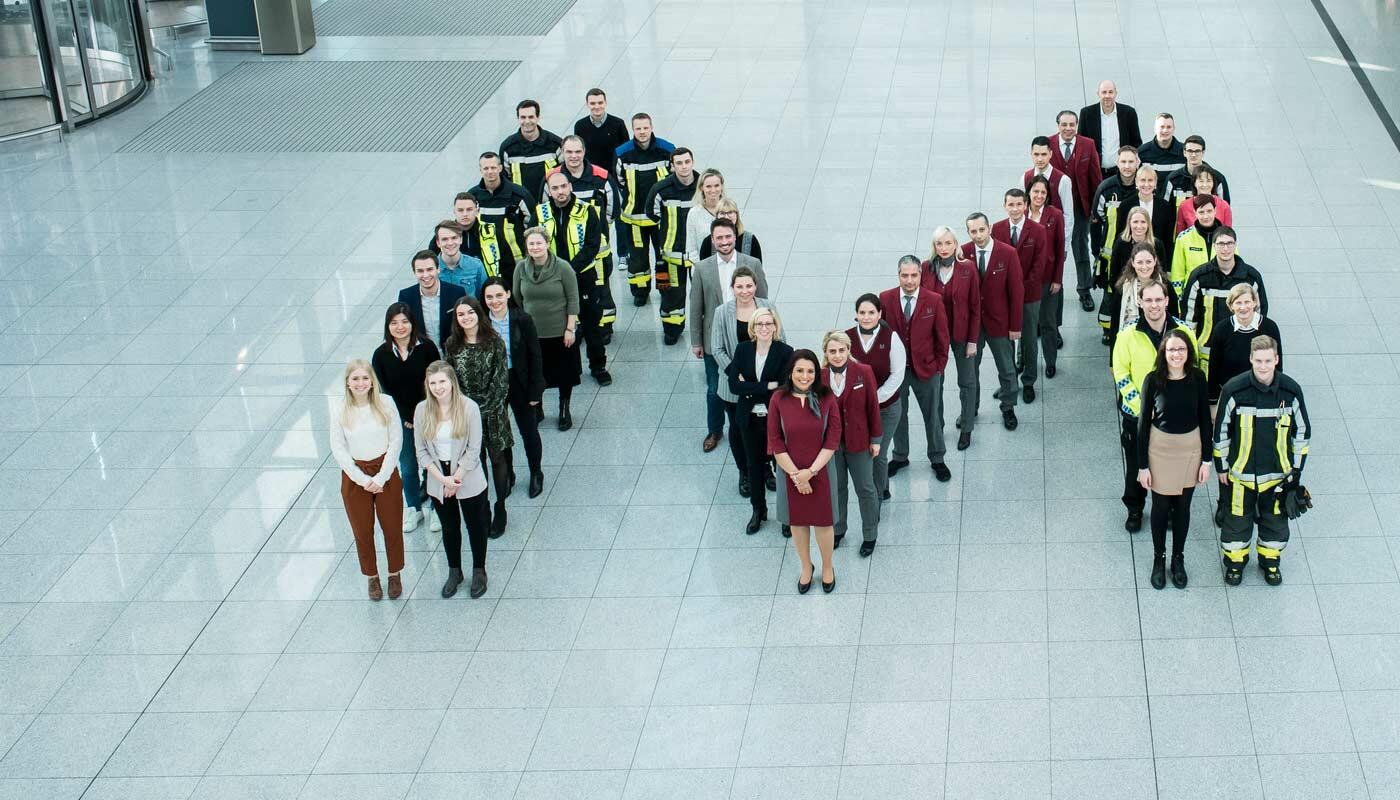 Staff at Munich Airport Different employees build the letter "M"