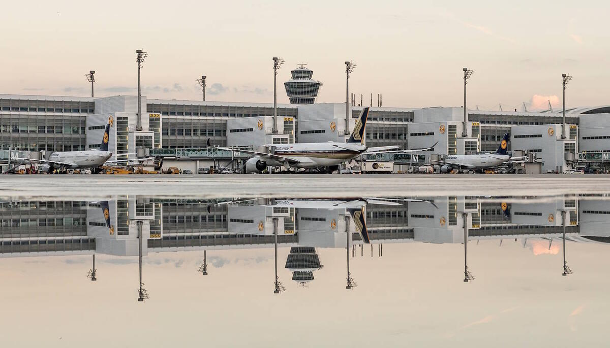 Wasserwirtschaft Vorfeld mit spiegelnder Vorfeldfläche und Terminal im Hintergrund