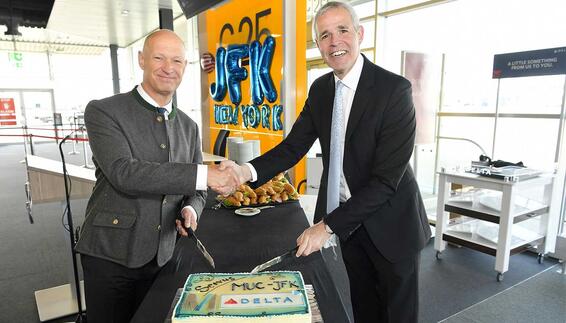 Auf dem Bild zu sehen sind links Jost Lammers (CEO Flughafen München) und Matteo Curcio (Delta Airlines Senior Vice President Europe, Middle-East, Africa, India) beim Anschneiden einer Torte am Gate anlässlich des Erstfluges nach New York, die anschließend unter den Passagieren verteilt wurde.