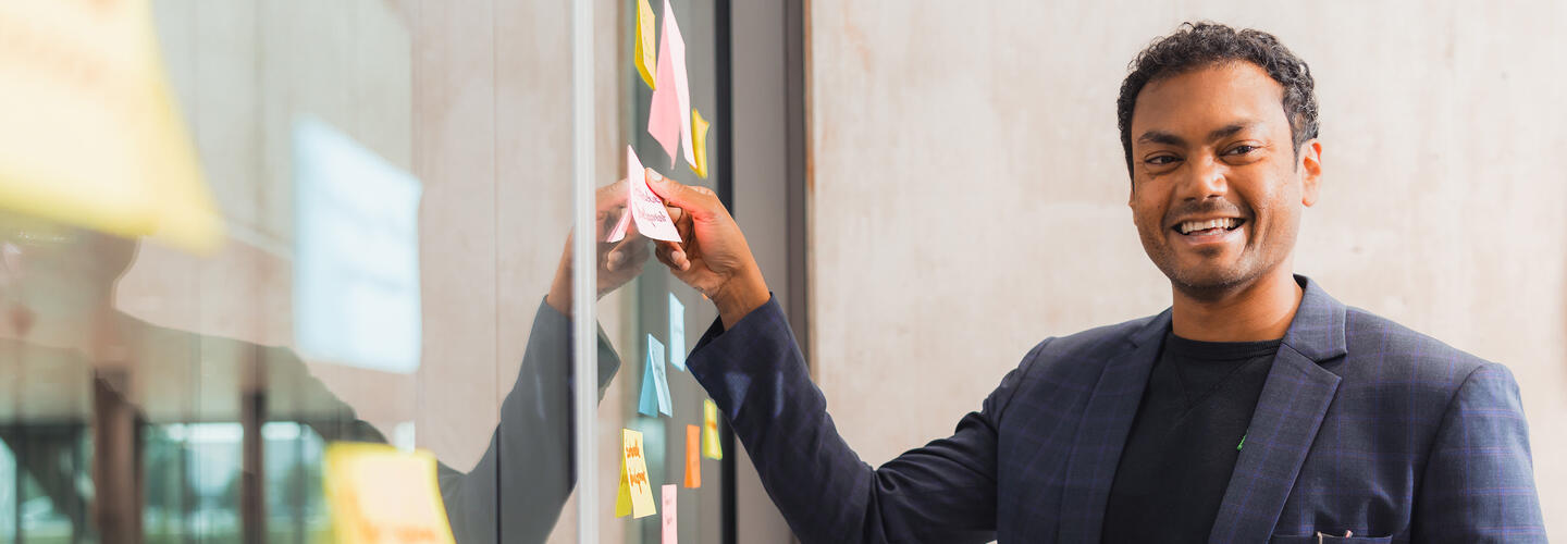 Trainings at Munich AirportAcademy Workshop participant sticks postits on a window pane