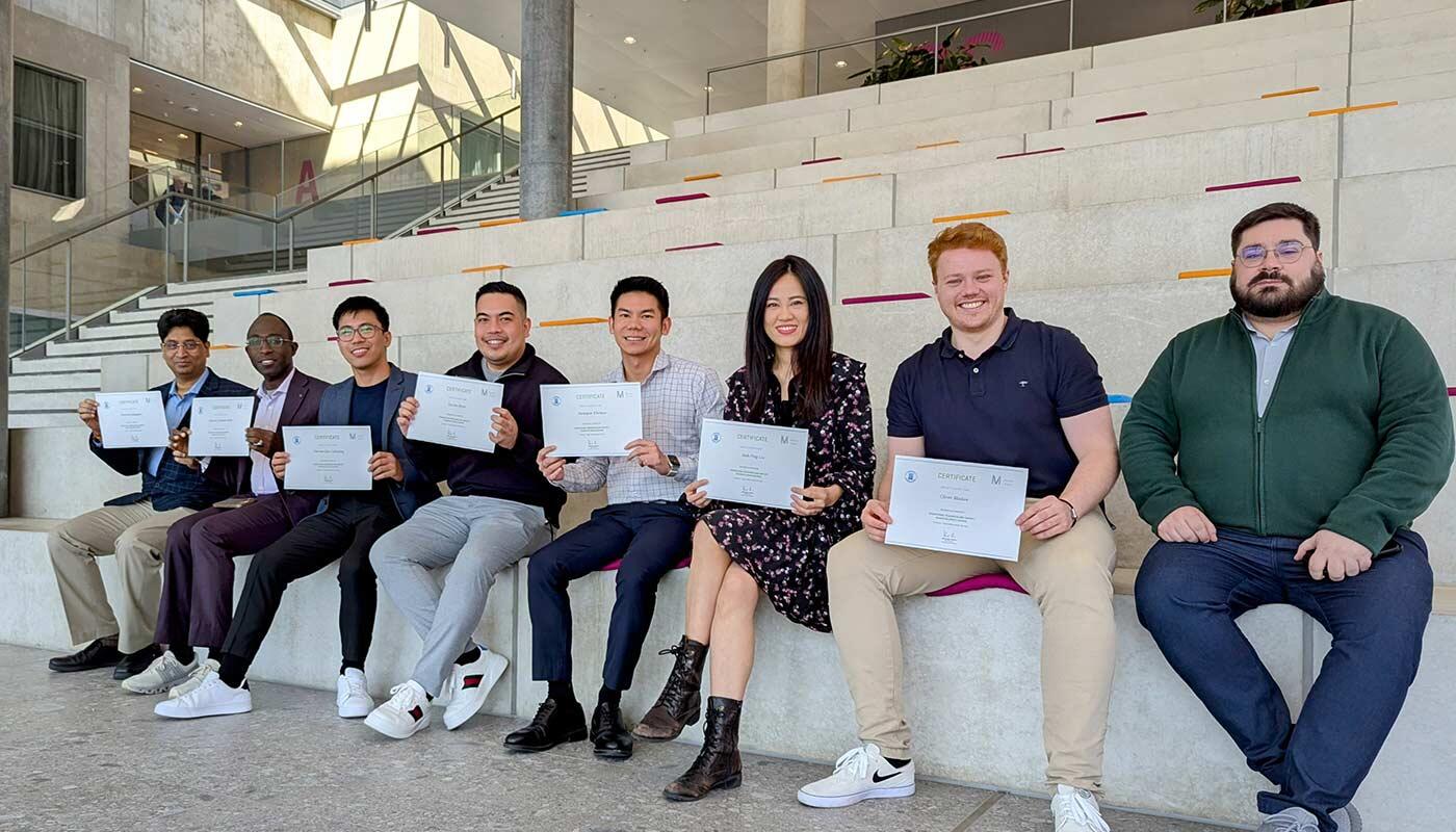 Group of training participants Group of training participants sitting on stairs in the LAB 52 AirportAcademy building with their certificates in their hands