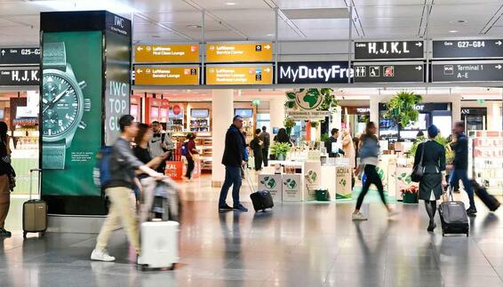 Geschäftiges Treiben am Flughafen mit Passagieren und Shops im Hintergrund