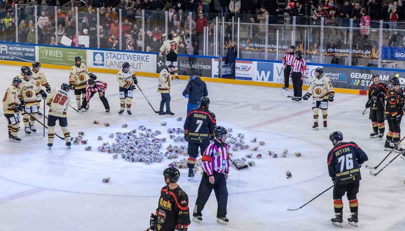 Teddy Bear Toss beim Benefiz-Eishockeyspiel – Kuscheltiere auf dem Eis in Landshut Eishockeyspieler und Schiedsrichter sammeln Teddybären auf dem Spielfeld nach einer Teddy-Bear-Toss Benefizaktion vor Zuschauern in der Arena.