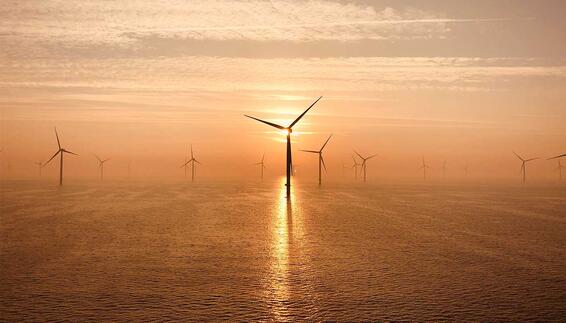 Offshore‑Windräder im Meer bei Sonnenuntergang