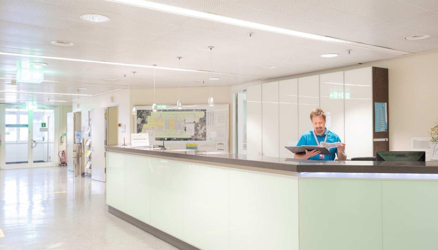 Impfberatung und Gesundheitsservice Empfangsbereich der Airport Clinic am Flughafen München, in dem medizinisches Personal Reisende berät. Die Szene steht für professionelle reisemedizinische Beratung und Impfangebote vor dem Abflug.