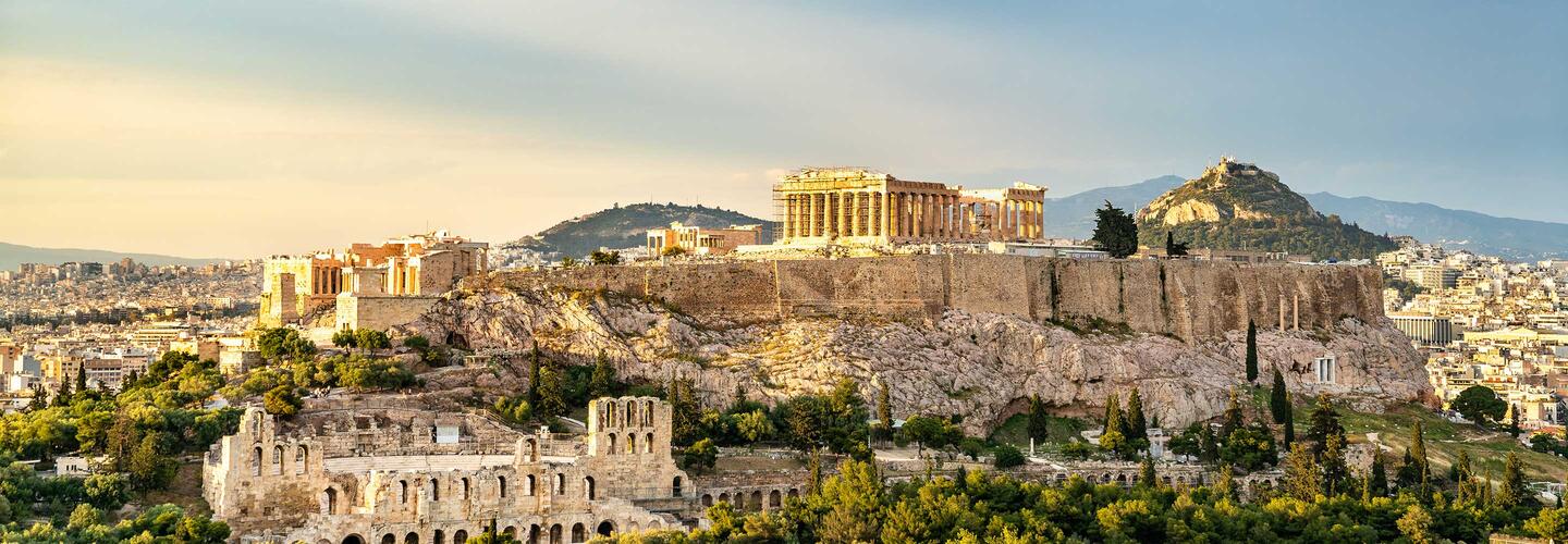 Städtereise Athen Akropolis auf Felsen und Stadt Athen im Hintergrund im warmen Sonnenlicht